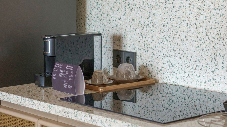 terrazzo counter and backsplash with electric stove and coffee machine