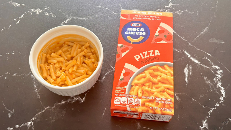 Kraft pizza mac and cheese box next to bowl of mac and cheese