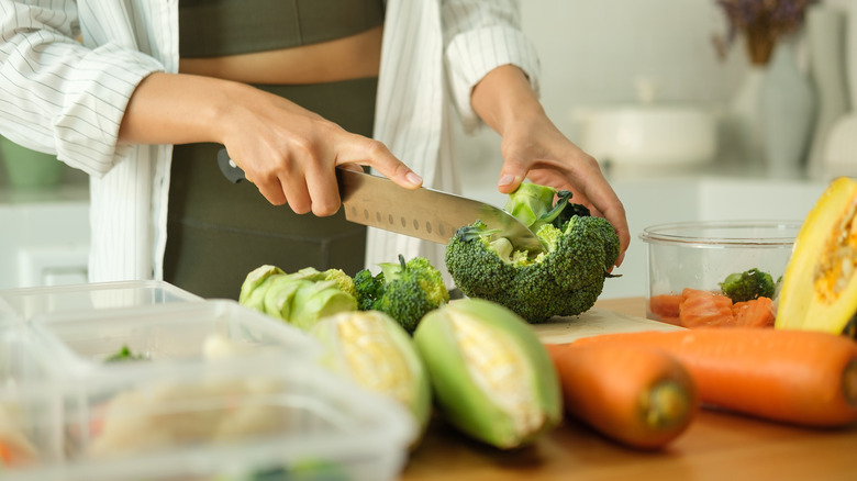 Woman cutting different vegetables