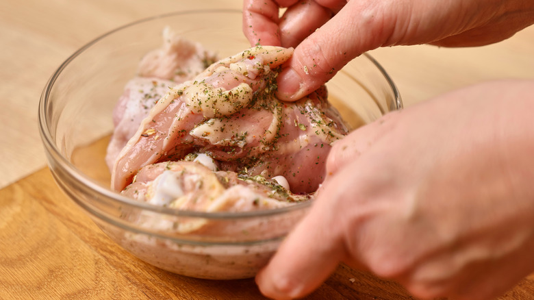 Person marinading chicken breast