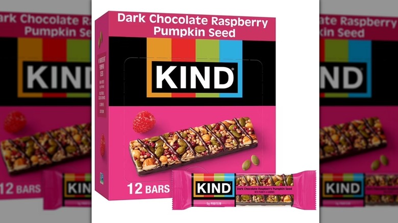 A box of Dark Chocolate Raspberry Pumpkin Seed KIND Snack Bars sitting against a white backdrop