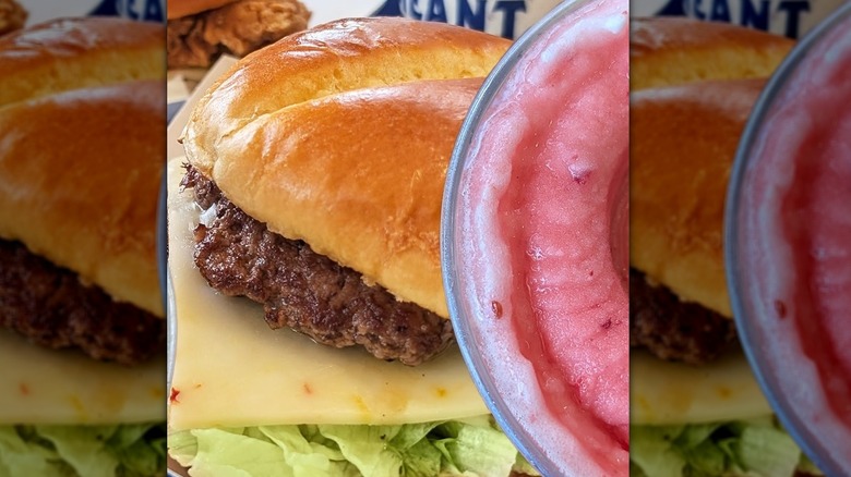 A double cheeseburger with visible lettuce and pepper jack cheese next to a pink slushie drink