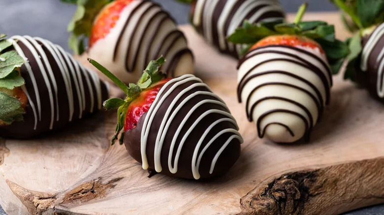 Chocolate covered strawberries on wood plank