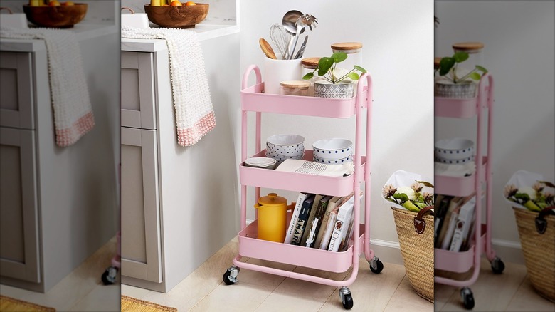 A pink metal rolling cart holding kitchen items