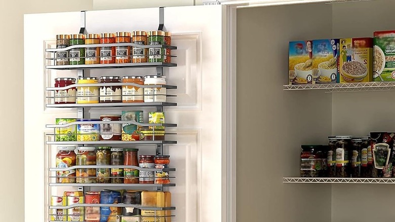 An over-the-door pantry organizer holding cans, spices, and jars