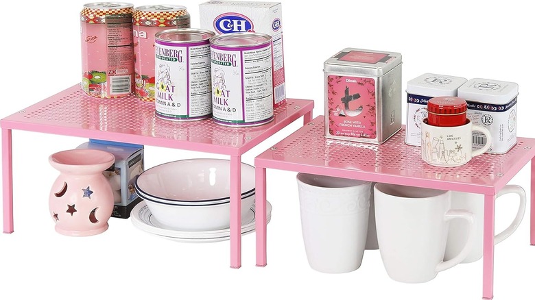 Small pink metal shelves holding food, tea, and dishes