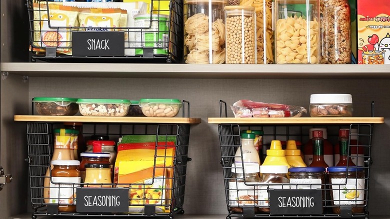 Wire baskets on pantry shelves holding condiments, snacks, and seasonings