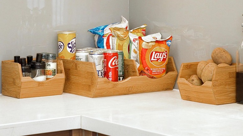 Wooden crates on a counter holding food, soda, and spices
