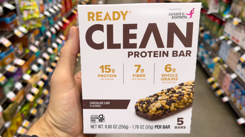 Close-up of a hand holding a box of Ready Clean Protein Bars in a grocery store