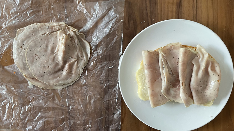 Spanish-style pork sandwich meat on a plastic sheet and an open sandwich
