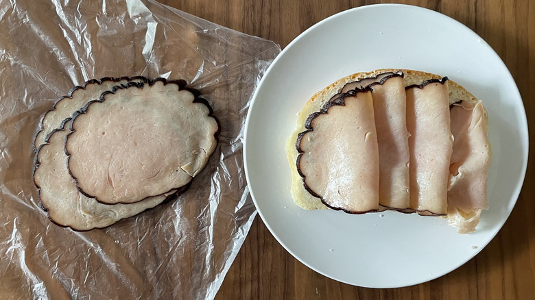 Maple smoked turkey on a plastic sheet and an open sandwich
