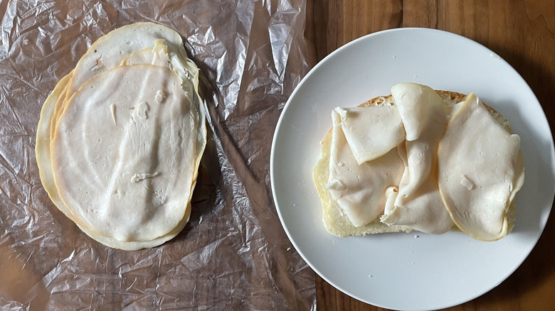 Smoked chicken breast on a plastic sheet and an open sandwich