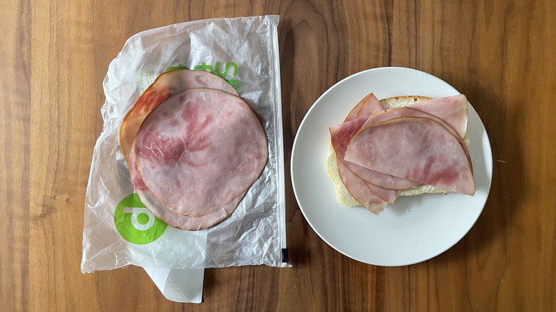 Sweet ham on a plastic sheet and an open sandwich