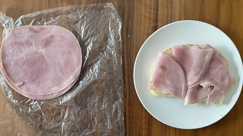 Regular ham on a plastic sheet and an open sandwich