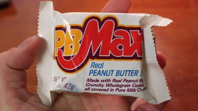 Hand holding up white PB Max bar
