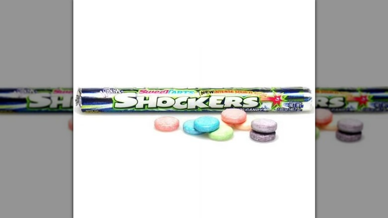 Roll of Shockers candy and individual candies on white background
