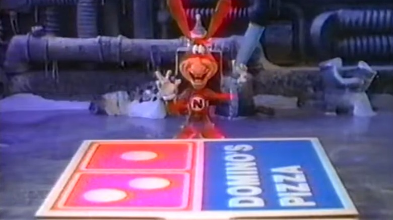 Domino's Noid mascot standing by pizza box