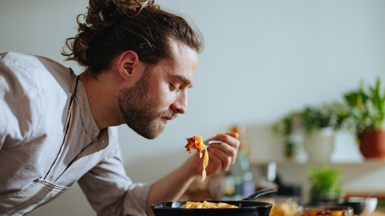 Chef tasting recipe while cooking