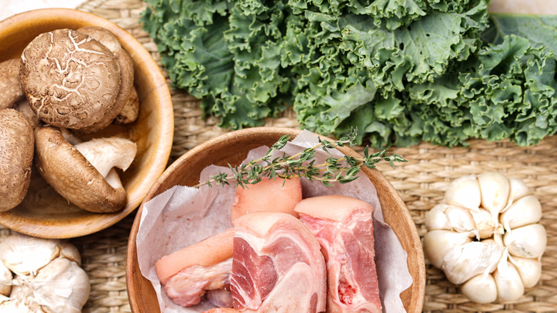 Spread of quality ingredients light greens, mushrooms, raw meat, and garlic