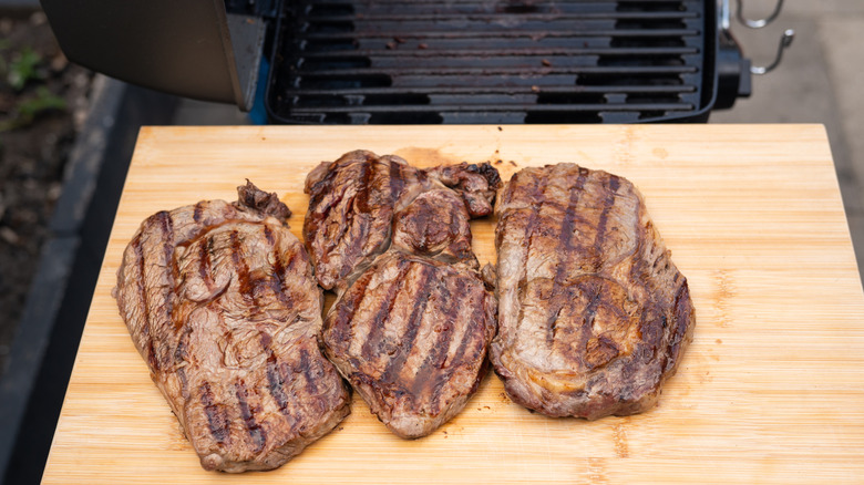 Three steaks resting after being grilled