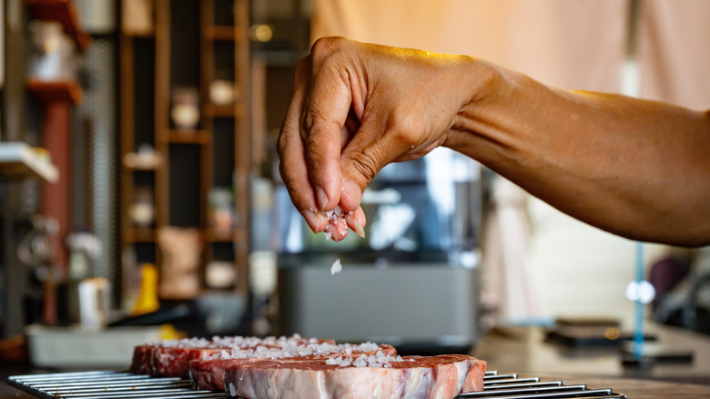 Close up of chef salting steak