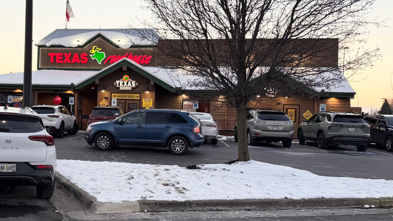 Cars parked outside of a snowy Texas Roadhouse