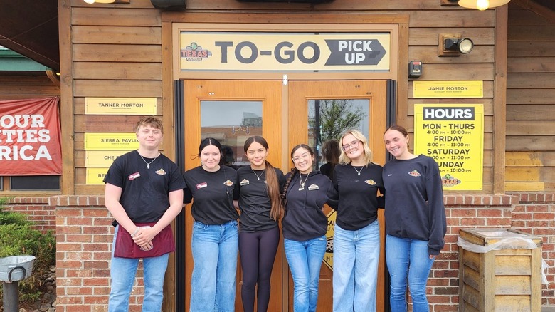Employees stand outside of a Texas Roadhouse
