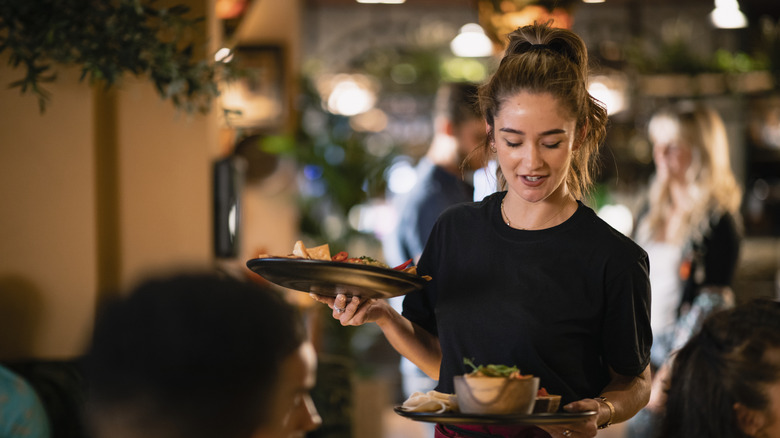 Server delivers plates of food to her table