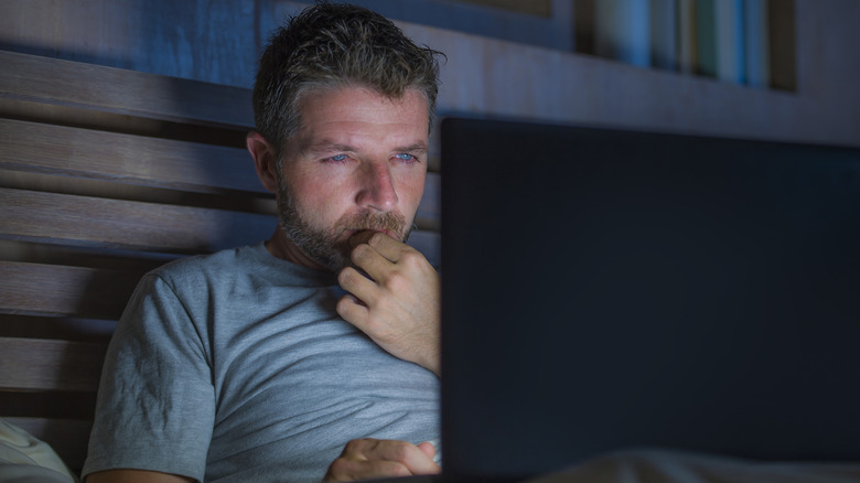 Person looking at computer with stressed expression