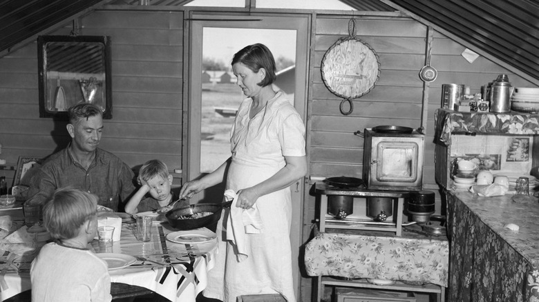 A family sits down to eat in their kitchen during the Depression