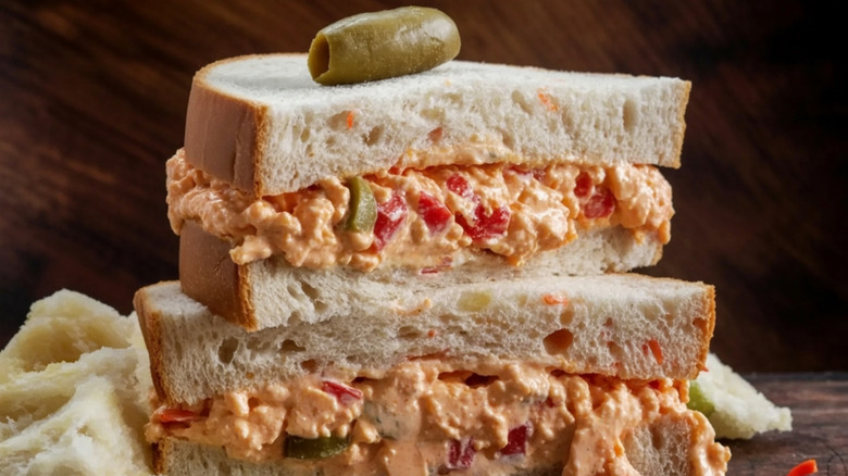 A pimento cheese sandwich double-stacked against a dark background