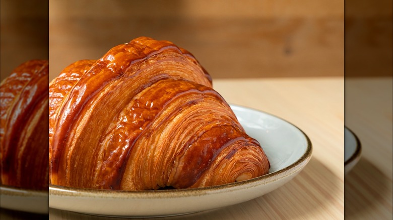 Croissant on a plate against a wooden background