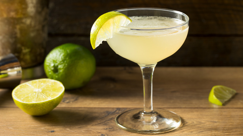 A classic daiquiri in a coupe with fresh limes