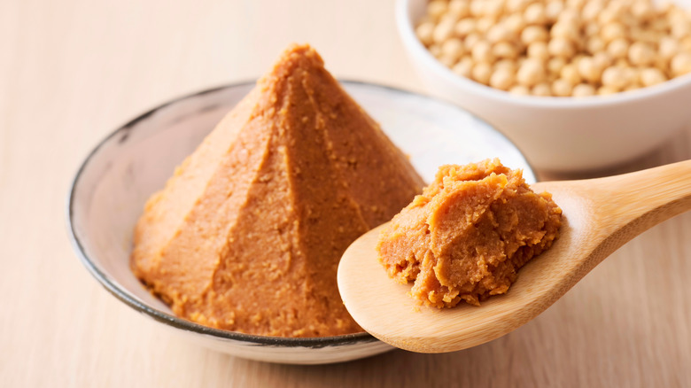 Miso paste on white plate and wooden spoon