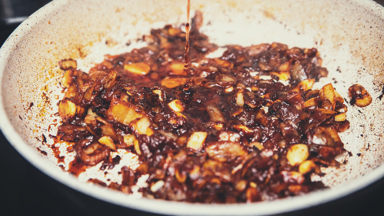 Wine deglazing onions in a pan