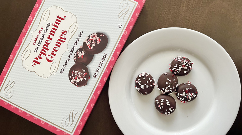 Peppermint cremes on a white plate and a box of Trader Joe's cremes next to the plate