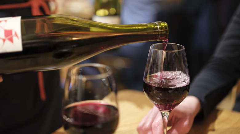 Red wine being poured into glasses