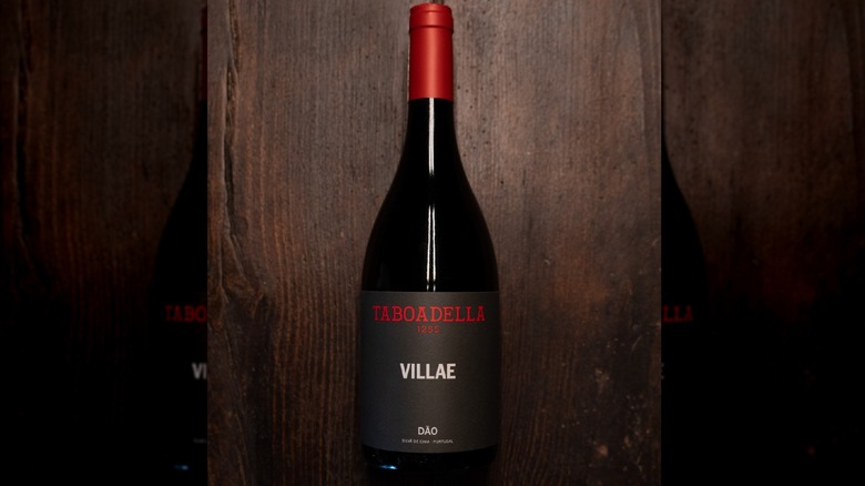Bottle of Taboadella Villae red wine on wood surface