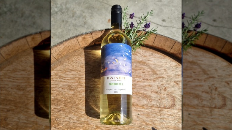 bottle of white wine lying on barrel