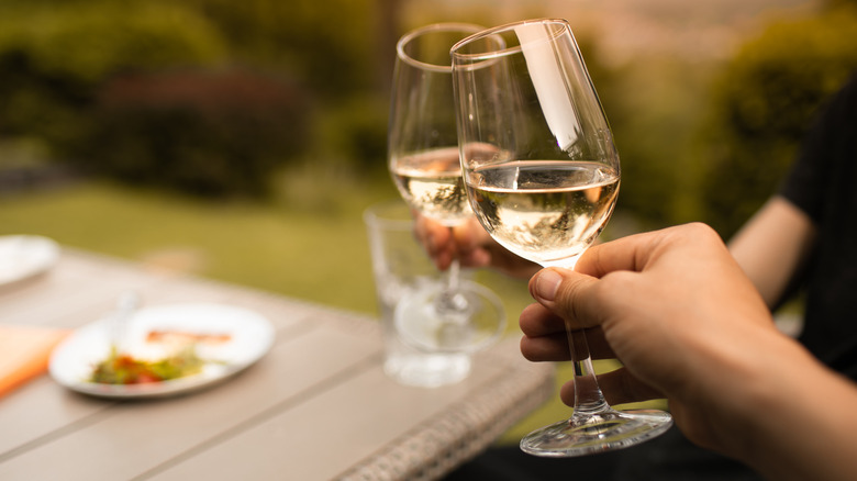 clinking white wine glasses