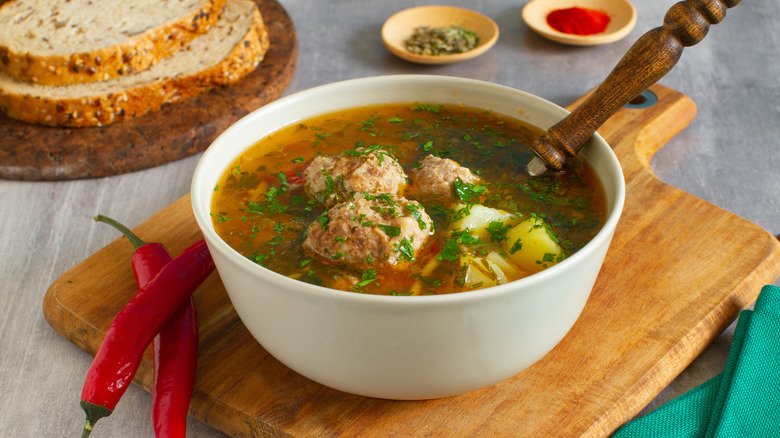 Meatballs in vegetable soup in white bowl
