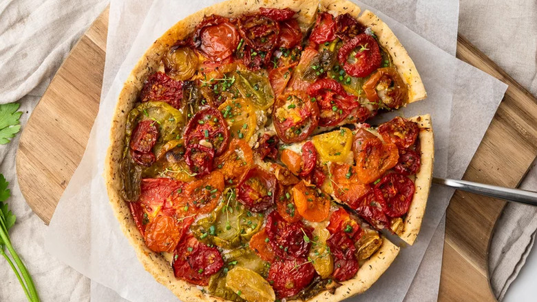 Heirloom tomato and cheddar pie on parchment paper.