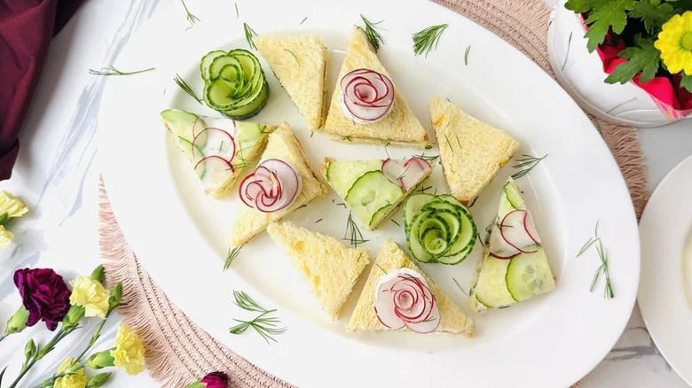 A plate of triangular smoked salmon sandwiches