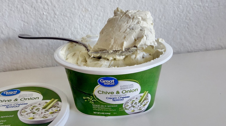 Pile of Great Value Chive & Onion Cream Cheese Spread on a spoon with a container underneath