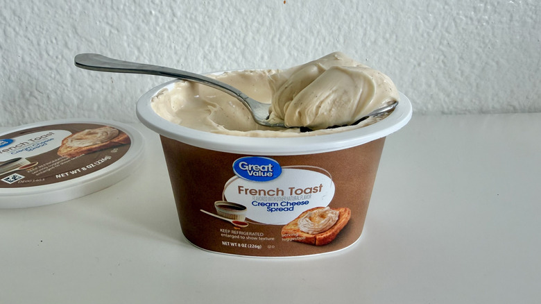 Open container of Great Value French Toast Cream Cheese Spread with a spoon holding some of the spread on top of the container