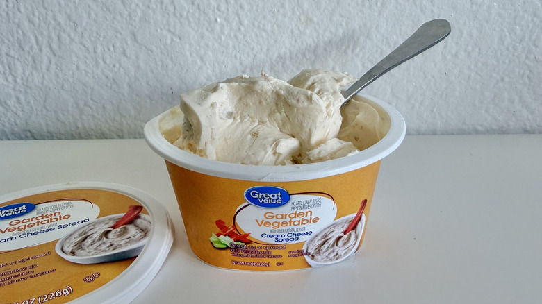 Open container of Great Value Garden Vegetable Cream Cheese Spread with a spoon tucked inside