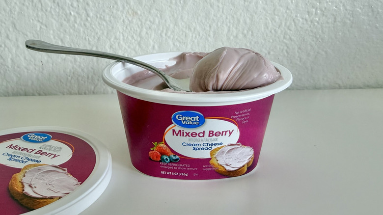 A tub of Great Value Mixed Berry Cream Cheese Spread on a spoon