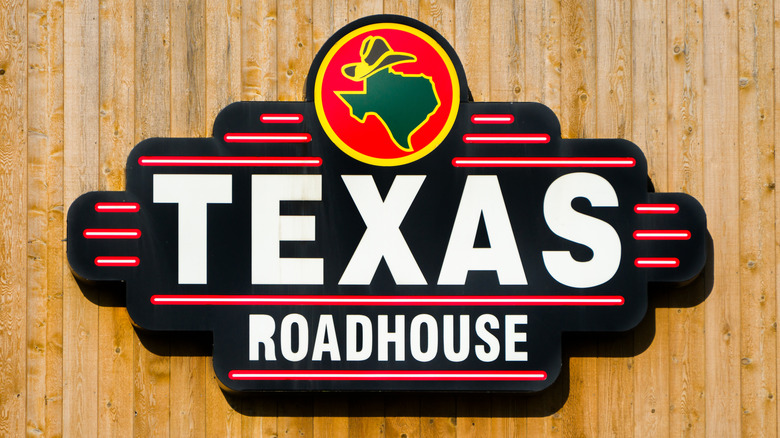 Texas Roadhouse logo against a wooden background