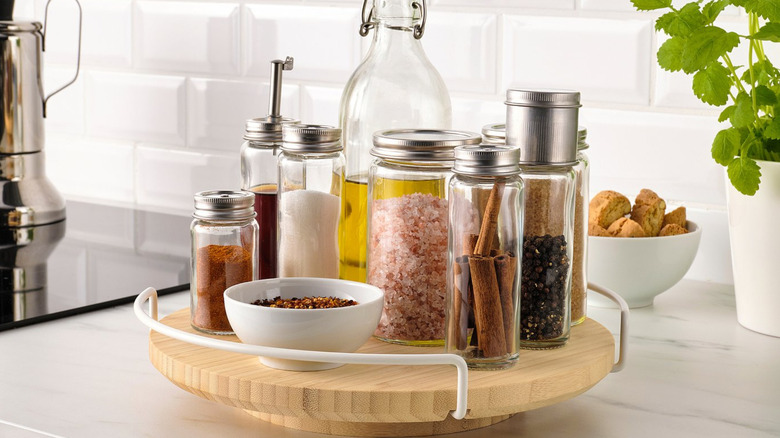 The Aptitlig lazy Susan with many spices and an olive oil bottle on top.