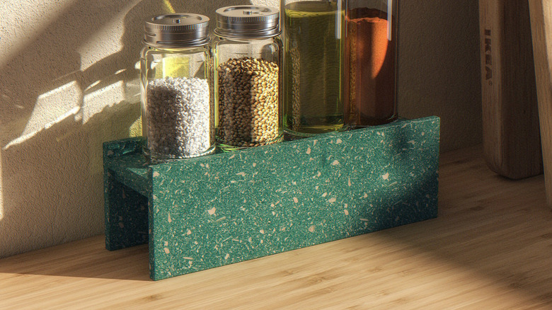 A Hundhaj green spice rack on a table with spices on top.